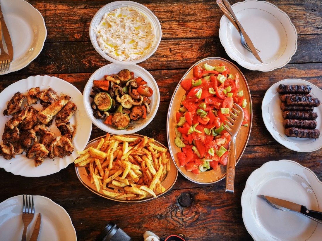 Albanien Backpacking Essen mit Tomaten-Gurken-Salat, Fleisch, Käse und Pommes